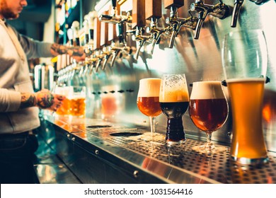 We meet oktoberfest. Hand of bartender pouring a large lager beer in tap. Pouring beer for client. Side view of young bartender pouring beer while standing at the bar counter - Shutterstock ID 1031564416