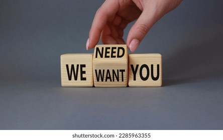 We need and want You symbol. Businessman Hand turns cubes and changes word We want you to We need you. Beautiful grey background. Business and We need and want You concept. Copy space