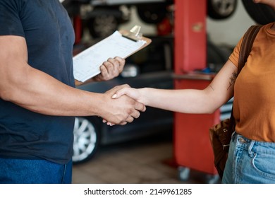 We Offer Great Service And Advice. Shot Of A Woman Shaking Hands With A Mechanic In An Auto Repair Shop.