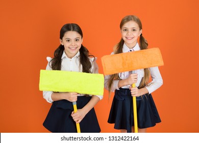 We Are On Duty Today. Pupil Cleaning Classroom. Nice And Tidy. Schoolgirls Mop Ready For Cleaning. School Duties. Little Helper. Girls Cute Kids School Uniform On Orange Background. Keep School Clean.