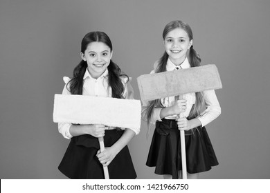 We Are On Duty Today. Pupil Cleaning Classroom. Nice And Tidy. Schoolgirls Mop Ready For Cleaning. School Duties. Little Helper. Girls Cute Kids School Uniform On Orange Background. Keep School Clean.