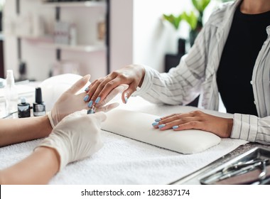 We Are Open, Reopening Of Beauty Salon. Female Master In Rubber Gloves Cover Blue Polish To African American Lady Client Nails In Studio Interior During Coronavirus Epidemic, Cropped, Free Space