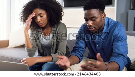 We really need to start changing our spending habits. Shot of a young couple using a laptop together and having an argument in the lounge at home.