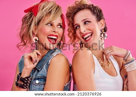 We share a love for 80s fashion. Studio shot of two beautiful young women styled in 80s clothing.