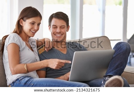 We should totally get that. An affectionate young couple doing some online shopping at home.