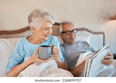 We still like the good old fashioned newspaper. Cropped shot of a senior man reading a newspaper in bed while his wife drinks a cup of coffee. - Powered by Shutterstock