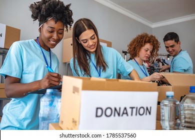 We Are Team Of Charitable People. Group Of Mixed Race People Working In Charitable Foundation. People Donating Food To Charity Food Bank Collection In Community Center