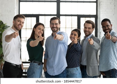 We are waiting for you! Group portrait of friendly successful diverse staff multiethnic teammates young men and women standing in row at office pointing fingers at camera choosing new colleague client - Shutterstock ID 1854447817