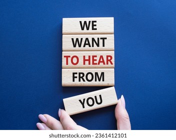 We want to hear from you symbol. Wooden blocks with words We want to hear from you. Beautiful deep blue background. Businessman hand. Business and We want to hear from you. Copy space.