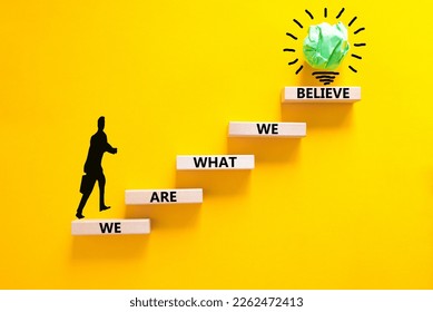 We are what we believe symbol. Concept words We are what we believe on wooden blocks. Businessman icon. Beautiful yellow background. Business, motivational we are what we believe concept. Copy space.