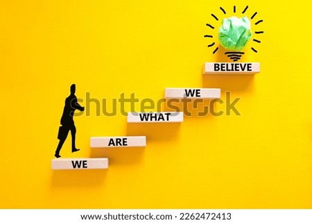 We are what we believe symbol. Concept words We are what we believe on wooden blocks. Businessman icon. Beautiful yellow background. Business, motivational we are what we believe concept. Copy space.