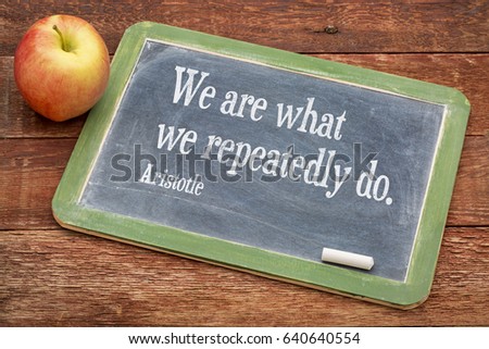 We are what we do - Aristotle quote on a slate blackboard against red barn wood - importance of habits and rituals