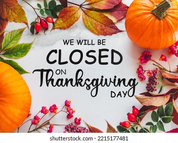 We will be closed for the Holidays. Beautiful Thanksgiving sign. Bright pumpkins, tree leaves, red berries and colorful flowers lying on an empty table. Close-up, top view. Holiday concept - Shutterstock ID 2215177481