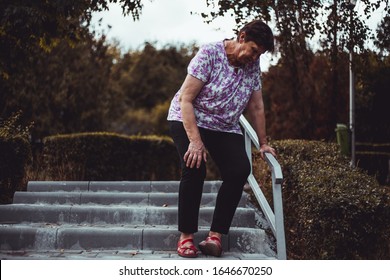 Weak Senior Woman About To Fall While Walking Down On The Stairs Outside - Cute Old Lady Slip In The Park - Elderly Female Whit Feet Pain And Muscle Discomfort