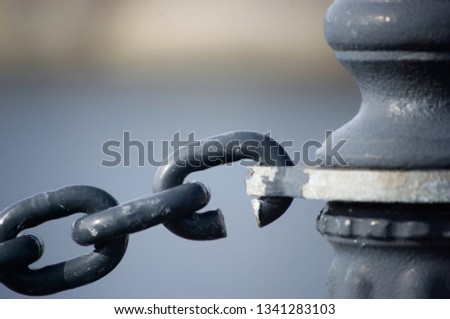 Weakest link chain attached to pole on harbor
