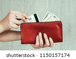 wealth and finances. money earning. cash and credit cards. welfare and income concept. woman hands holding a red leather wallet full of currency.