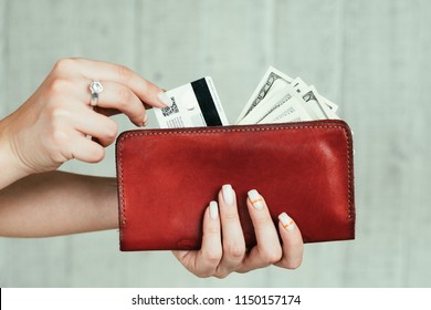 Wealth And Finances. Money Earning. Cash And Credit Cards. Welfare And Income Concept. Woman Hands Holding A Red Leather Wallet Full Of Currency.