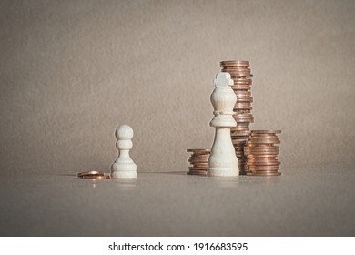 Wealth And Poverty. Disparity Between Rich And Poor. Whoever Has Money Holds The Power. Chess Pawn With A Couple Of Coins In Front Of A King With Lots Of Coins. Conceptual Image.