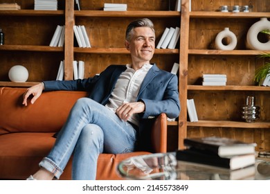 Wealth prosperity and fame. Relaxed successful caucasian mature middle-aged businessman freelancer boss ceo resting sitting on the sofa after hard-working day in home office. Taking a break