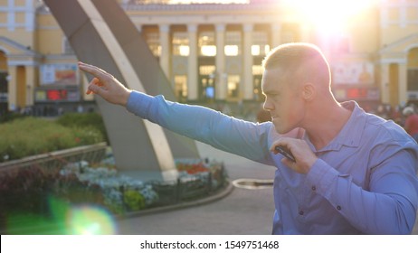 Wealthy Businessman Using Smart Phone At City Environment And Rejoicing Achievement. Successful Man Celebrating Luck In Business Or Successful Deal. Portrait Of Guy With Joyful Emotions. Slow Mo