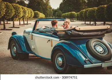 Wealthy Couple In Classic Convertible