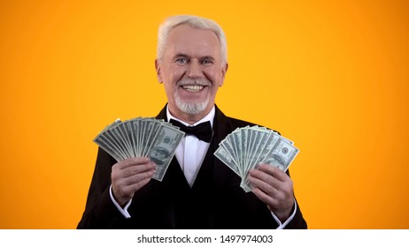 Wealthy Elderly Man In Suit Holding Dollars And Smiling, Successful Business