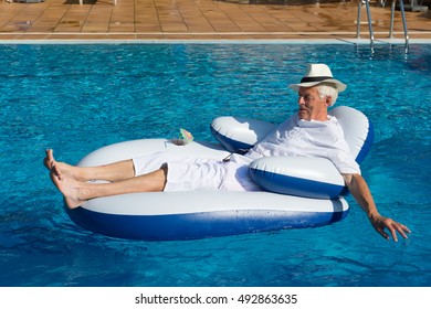 Wealthy Man Relaxing In Own Swimming Pool