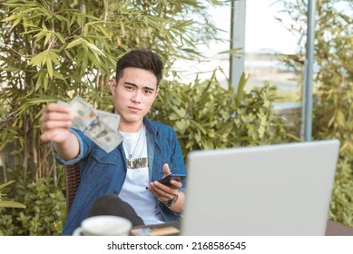 A Wealthy And Pompous Man Gives A Large Tip While Browsing On His Phone. Remote Working At An Outdoor Cafe Or Coffee Shop.