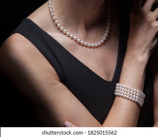 Wealthy upper middle class house wife well dressed rich privileged executive Caucasian successful woman adorns her prized natural pearls expensive jewelry while in a black evening dress - Powered by Shutterstock