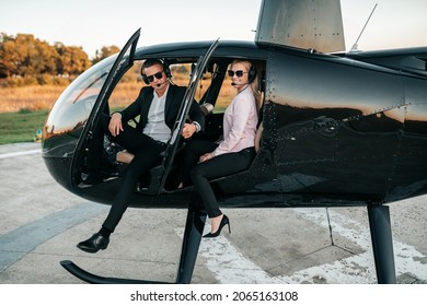 Wealthy young business couple is preparing to use their own private chopper or helicopter to travel on vocation or business meeting.