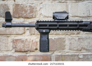 Weapon And Military Equipment For Self Defence. Gun Isolated On Old Rusty Brick Wall Background. Front Grip For A Shot Gun. Handgun Ready To Use. 