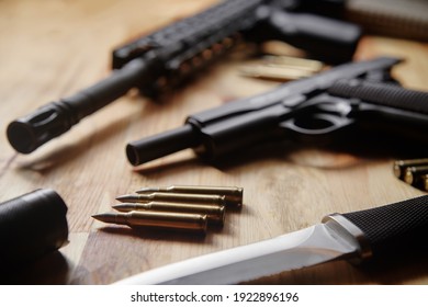 Weapons and military equipment for army, Assault rifle gun, handgun and knife on wooden background.