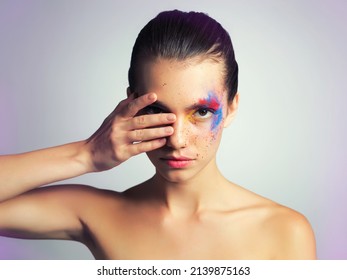 Wear War Paint And Keep Your Eye On The Prize. Studio Shot Of An Attractive Young Woman Posing With Her Face Brightly Painted.