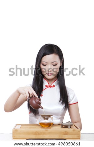 	Wearing cheongsam Oriental young woman in preparation for the tea ceremony	
