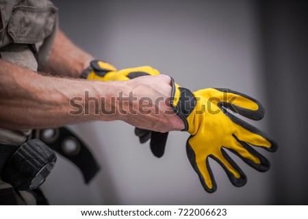 Wearing Construction Safety Gloves Closeup Photo. Caucasian Contractor Preparing For a Job.