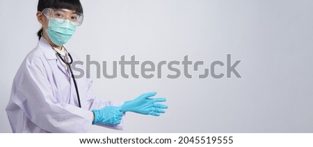 Wearing gloves. Asian doctor wear blue rubber nitrile hands glove. Doc with a mask putting on gloves. isolated white background copy space. Health care protection coronovirus pandemic concept. 