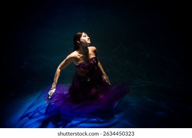 wearing in a lilac robe brown-haired lass is undersea in the pool