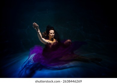 wearing in a lilac robe brown-haired lass is swimming underwater in the pool