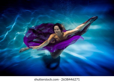 wearing in a purple dress lass is underwater in the swimming pool