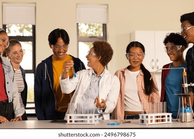 Wearing safety goggles, students conducting science experiment in high school classroom. education, chemistry, lab, learning, STEM, teamwork - Powered by Shutterstock