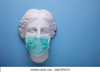 Wearing A Single Use Medical Protection Mask, Greek Gypsum Statue With Surgical Mask On Blue Background