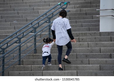 Wearing The Uniform Of A Professional Baseball Team That Mother And Baby Support, They Are Climbing The Steps Of A Baseball Stadium. (Seoul, Korea. Oct. 6, 2019)