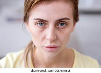 Weary face. Portrait of a pale exhausted woman looking at you while being ill - Shutterstock ID 1087676618