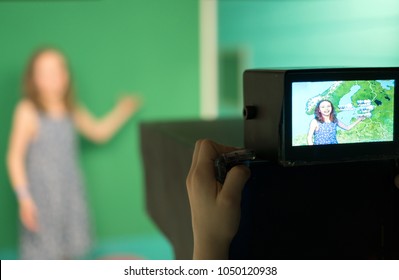 Weather Forecast. Little Girl Standing In Front Of Camera On Green Screen.