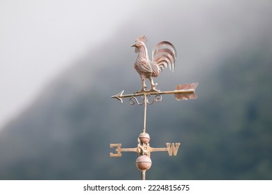 Weather vane against a mountain background