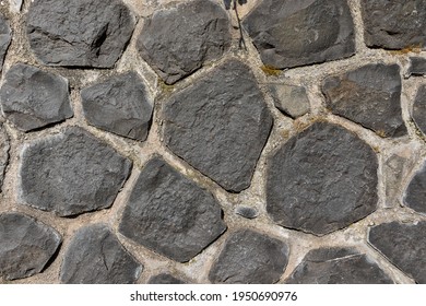 Weathered Basalt Boulder Rock Wall In Gray Black Anthracite Colors Grouted With Cement, Grout. Texture Without Vignetting