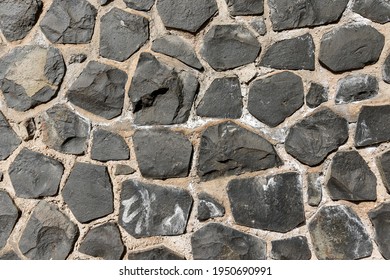 Weathered Basalt Boulder Rock Wall In Gray Black Anthracite Colors Grouted With Cement, Grout. Texture Without Vignetting