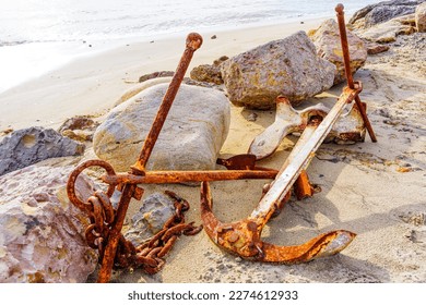 Weathered beauty of old, rusty anchors and chains on a sandy beach adding a sense of history and character to any project. - Powered by Shutterstock