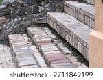 Weathered bricks form charming steps, surrounded by rugged stone and greenery.
