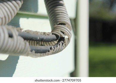 Weathered and broken electrical wire insulation outdoors